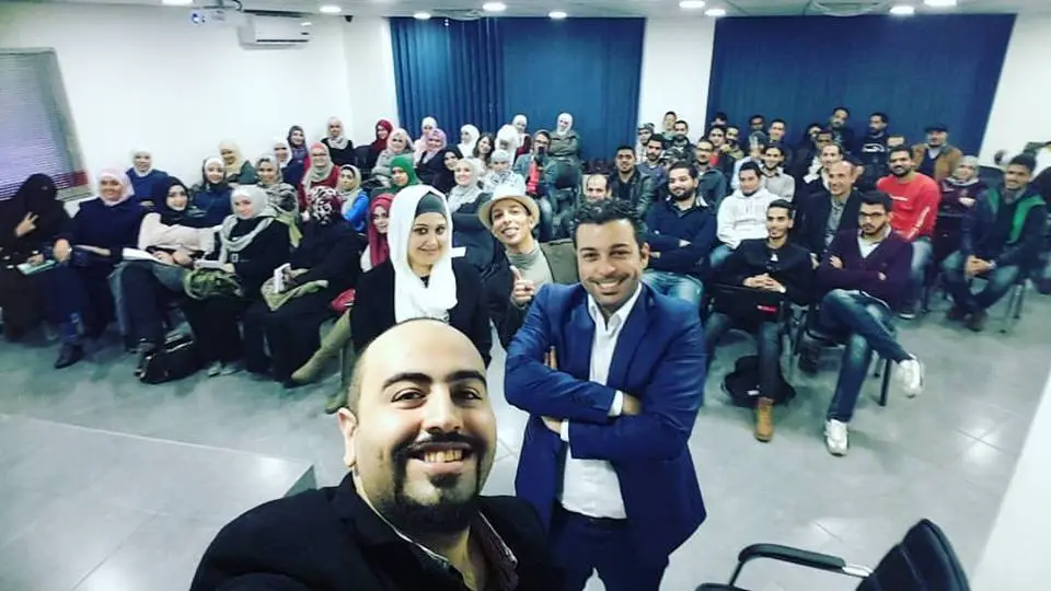 صورة جماعية مع المشاركين في قاعة تدريب